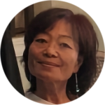 A woman of East Asian descent, Korean, with tan coloured skin and dark mid length hair